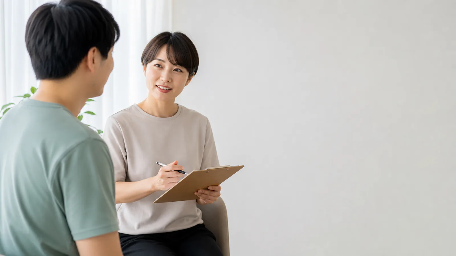 東亞成人在明亮空間與專業人員交談